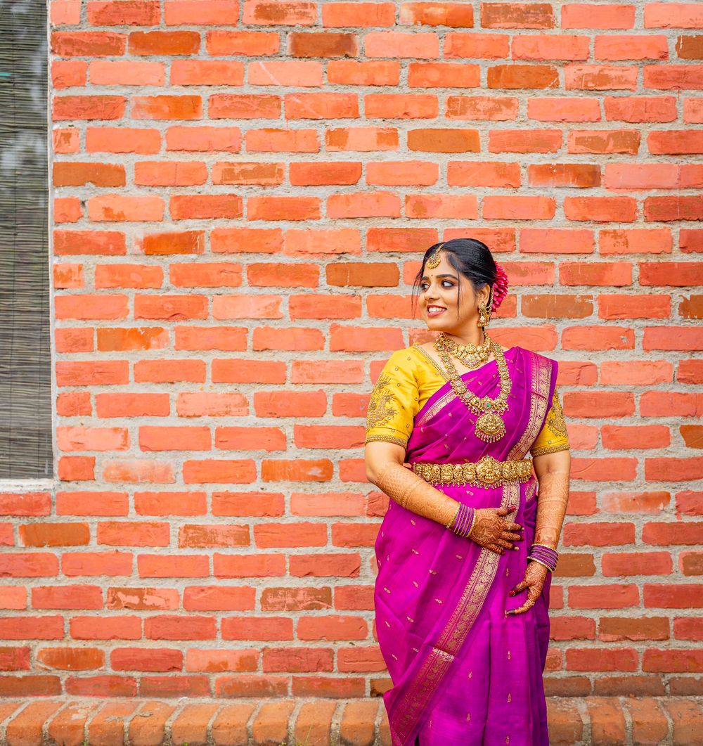 Traditional South Indian attire showcased against rustic brick wall background.