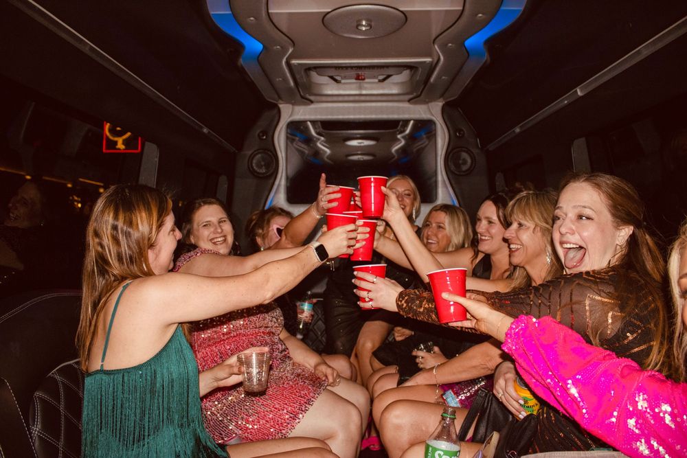 Women toasting with red Solo cups inside a party limousine in Las Vegas.