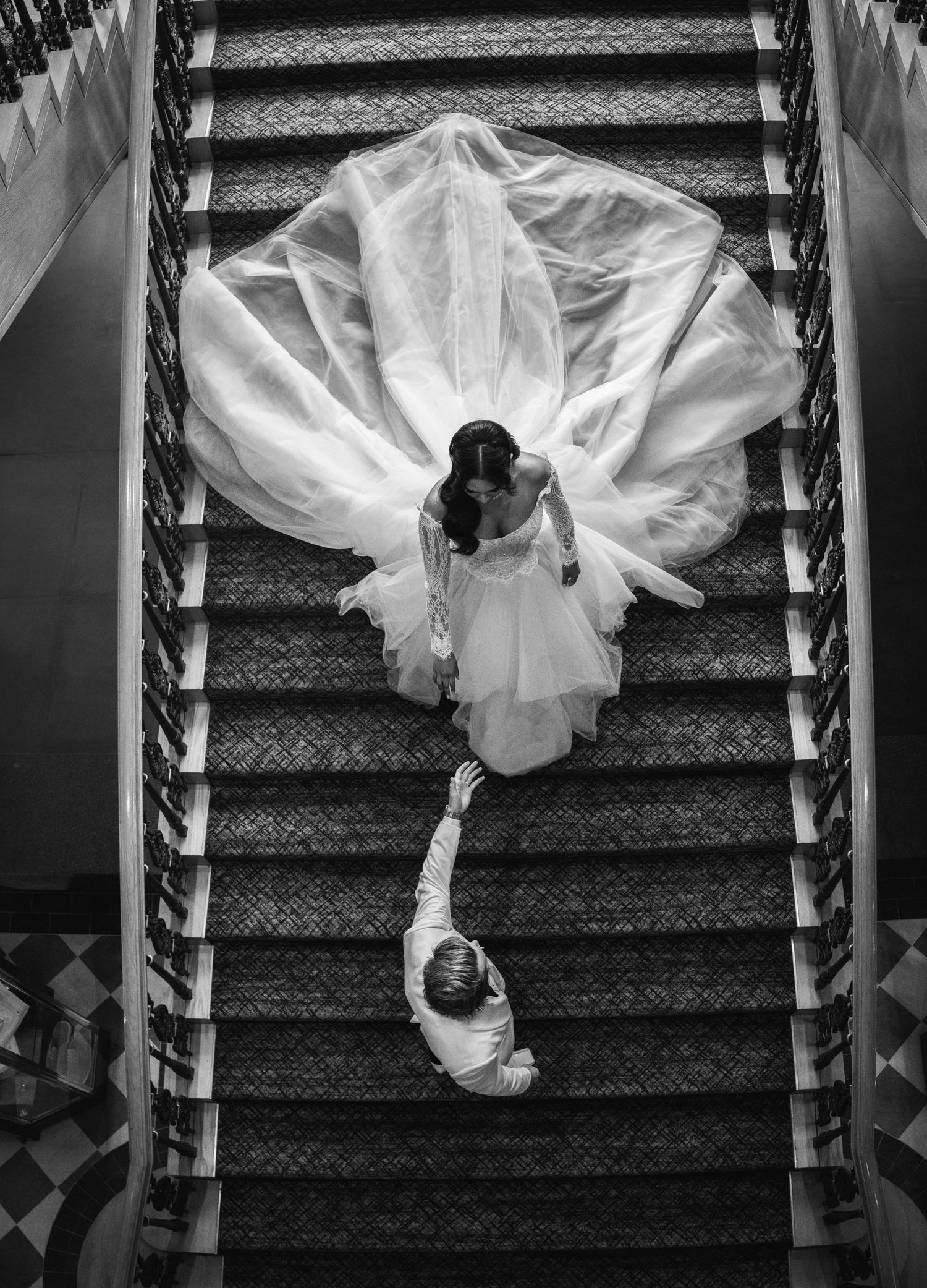 black and white photograph of bride and groom running