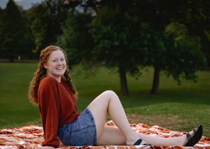 A series of outdoor portrait photos showing someone in a rust-colored sweater and denim shorts on a sunny day.
