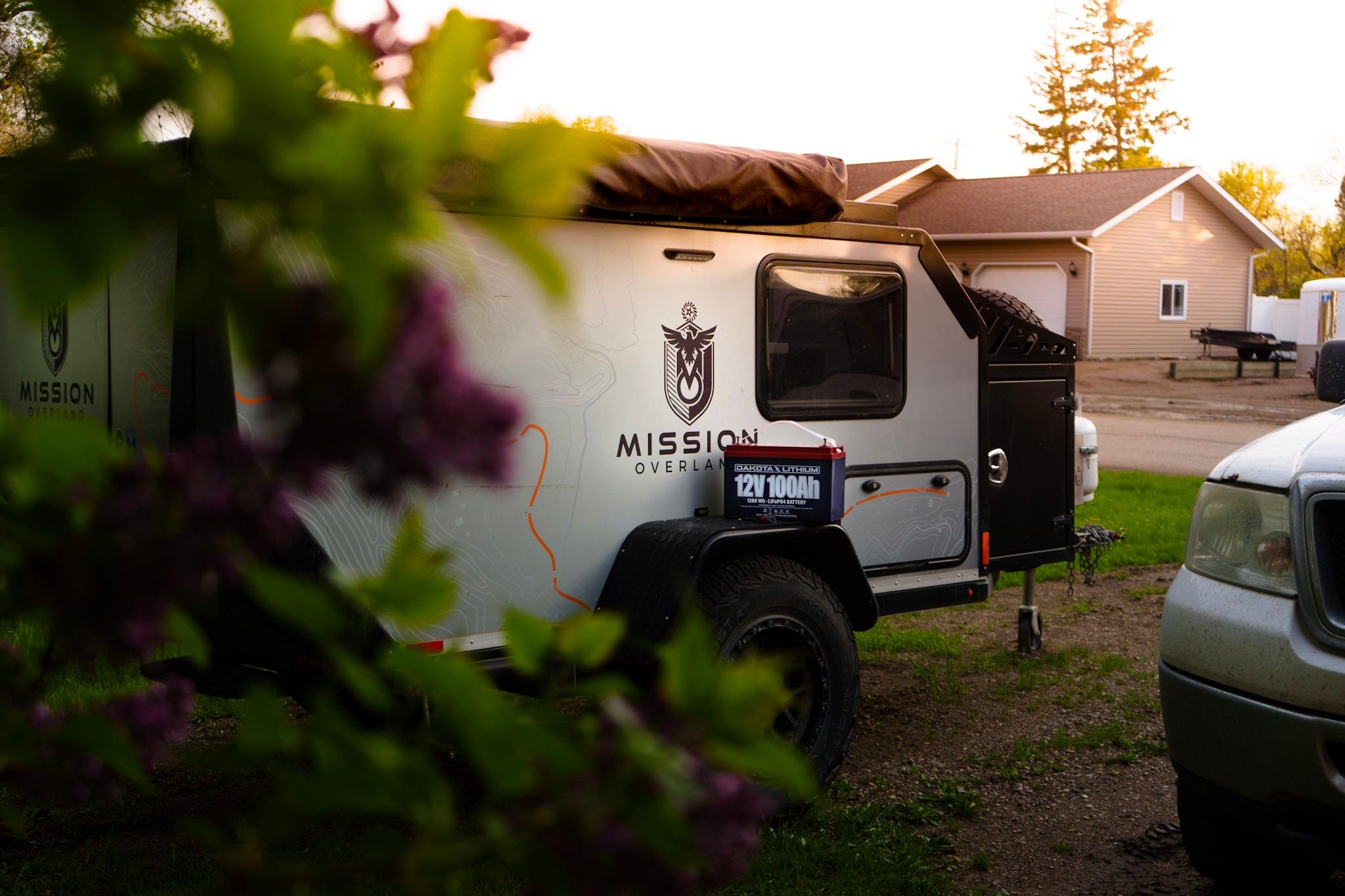 Mission camper trailer parked at a campsite during golden hour.