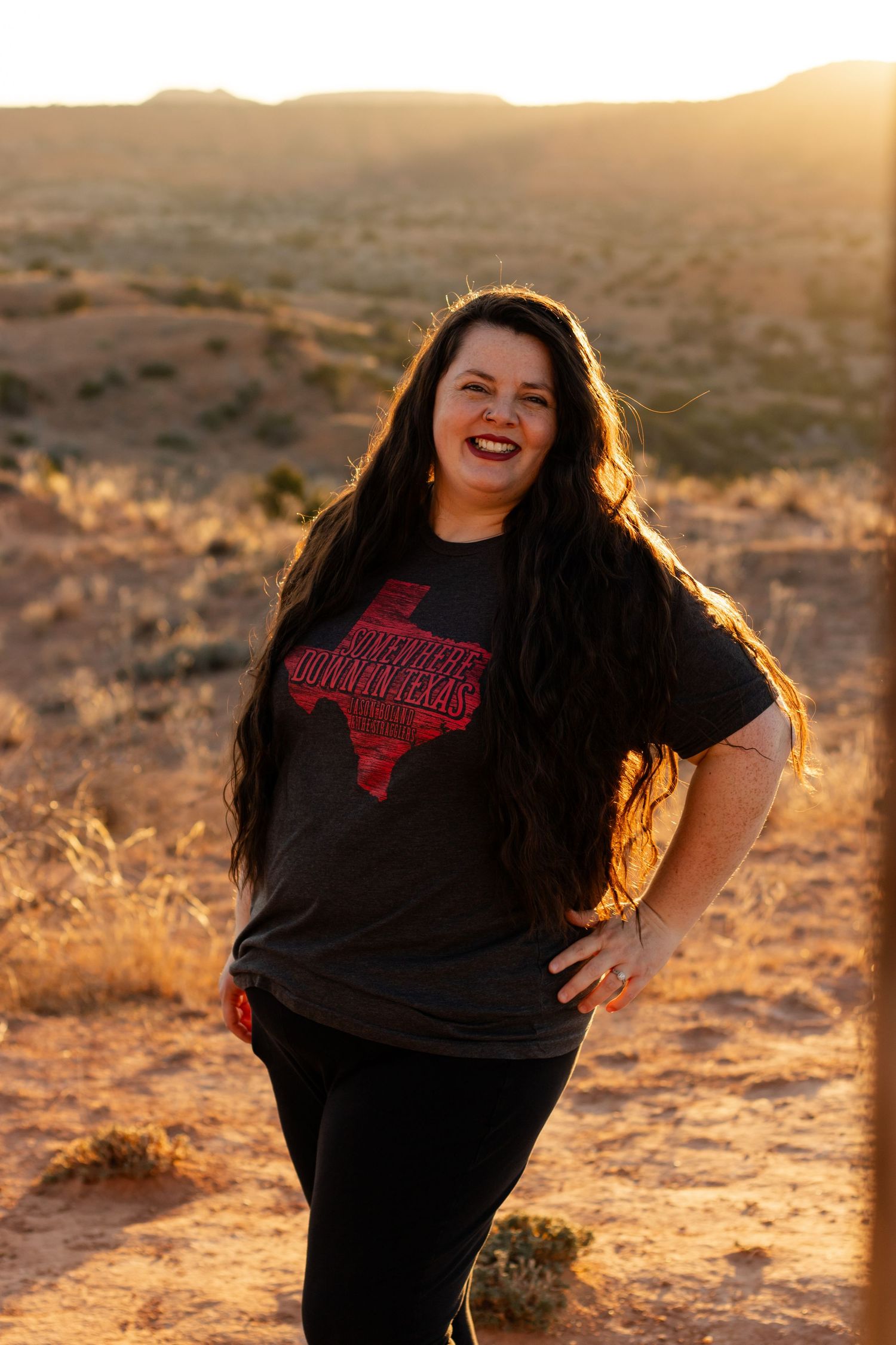 A voluptuous photographer smiles for portrait during golden hour at Caprock Canyons State Park in Texas while Buffalo watching.