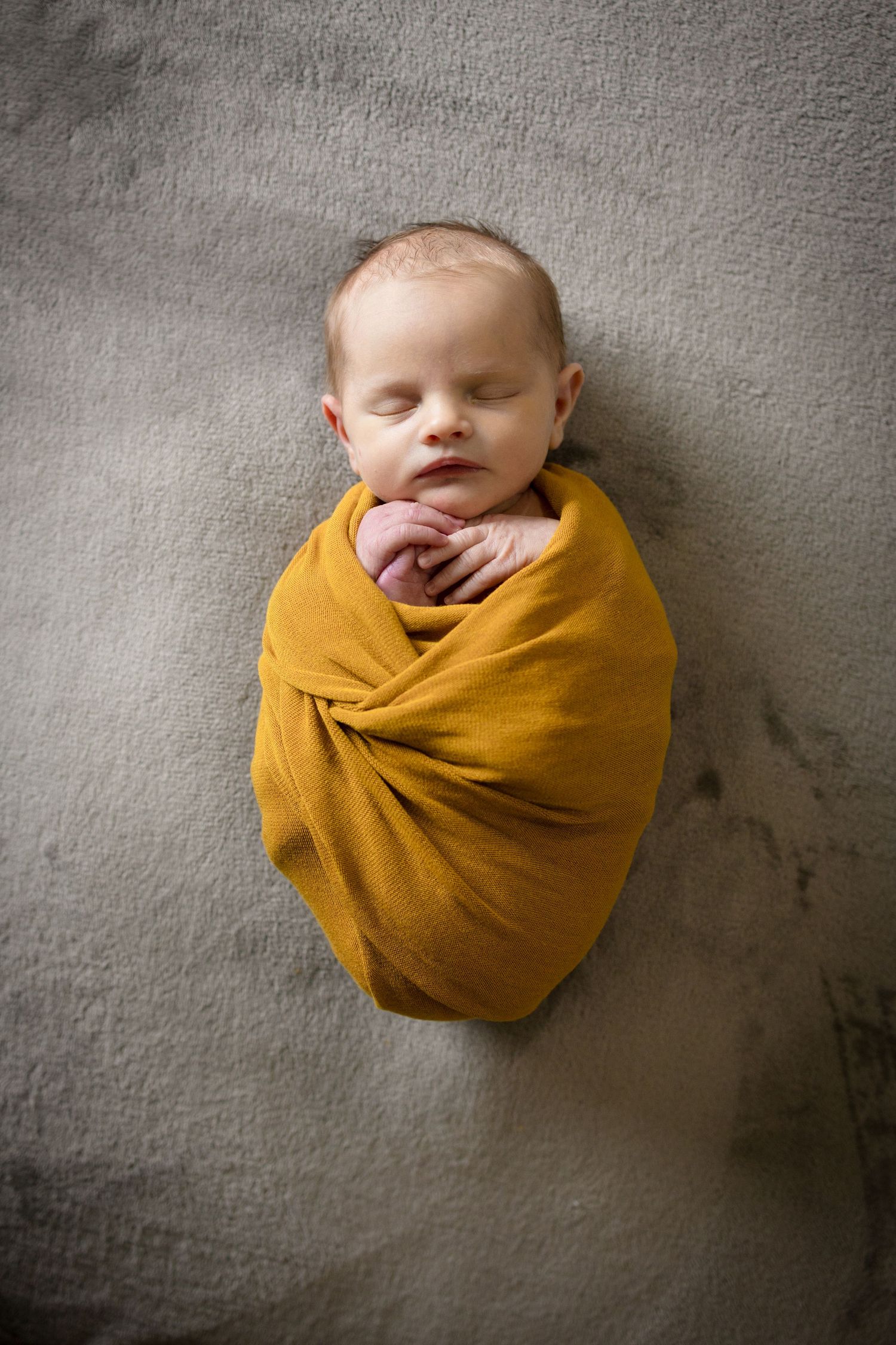 baby in a basket holding mother's jewelry covered with a red lacy scarf