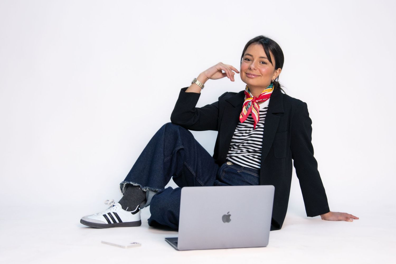 Person in business attire relaxing with laptop on white background.