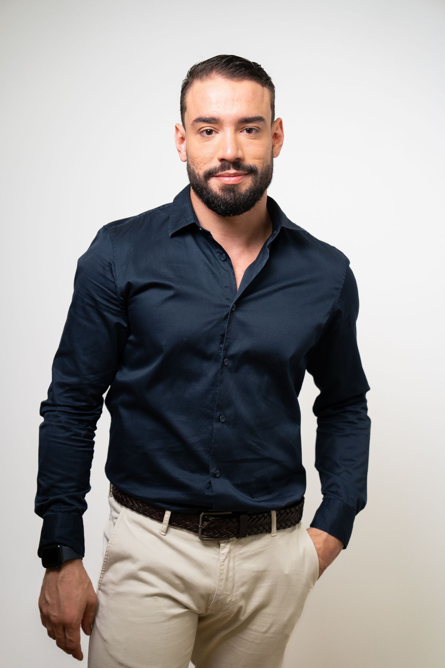Professional portrait series showing a person in a navy button-down shirt and khaki pants against white background.