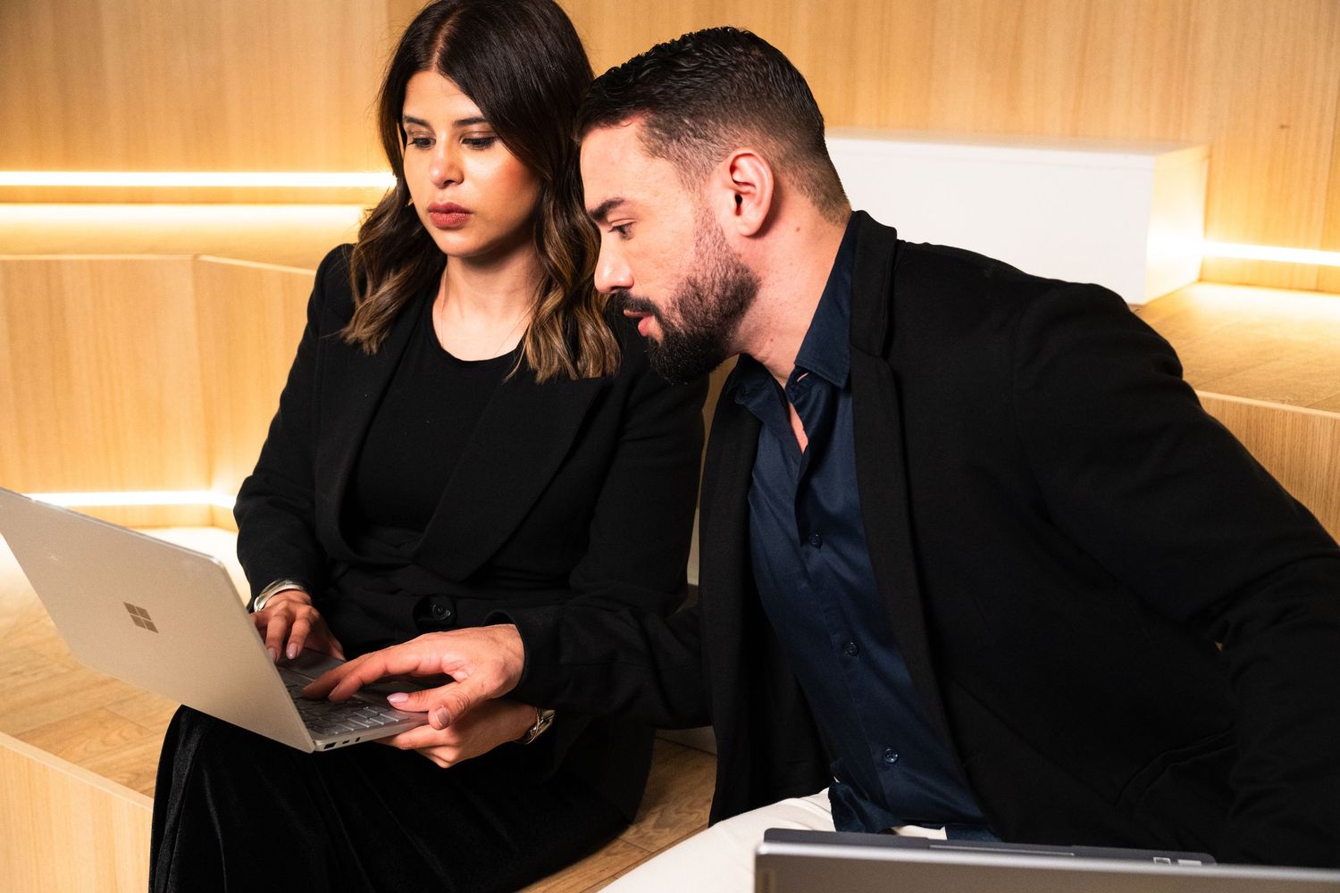 Professional duo collaborating and working together in modern office setting.