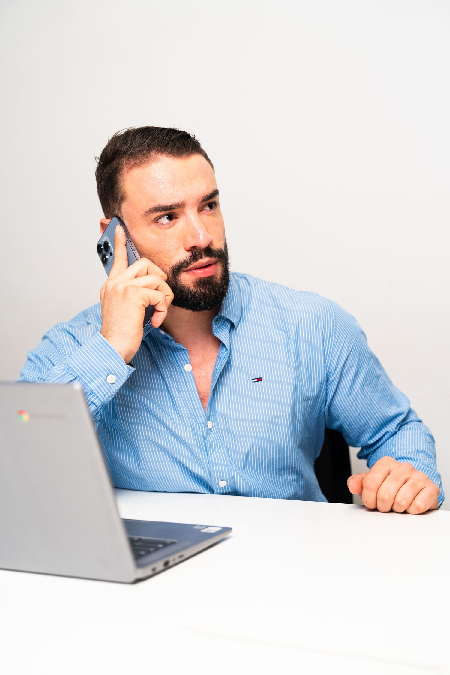 Person in light blue shirt working on laptop in professional office setting.