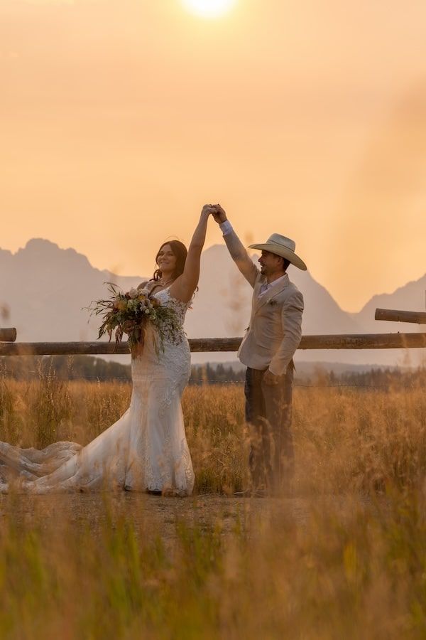 A serene silhouette of a couple dancing in a golden field during sunset, creating a romantic outdoor atmosphere.