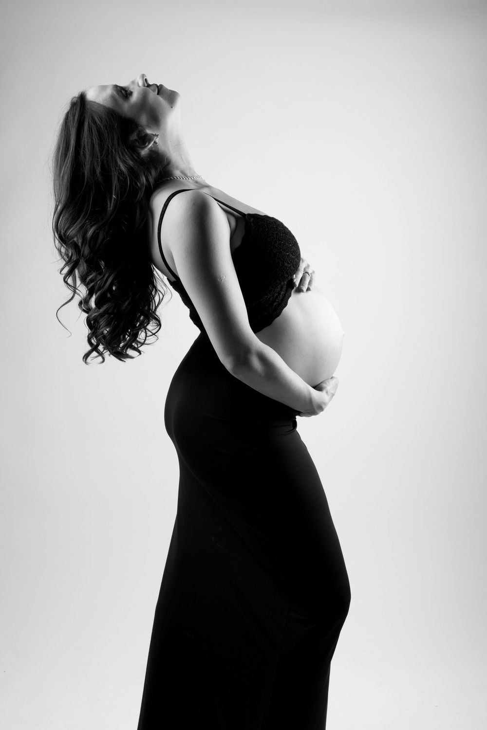 Black and white maternity photo series showing silhouette of pregnant woman's belly in artistic profile poses.