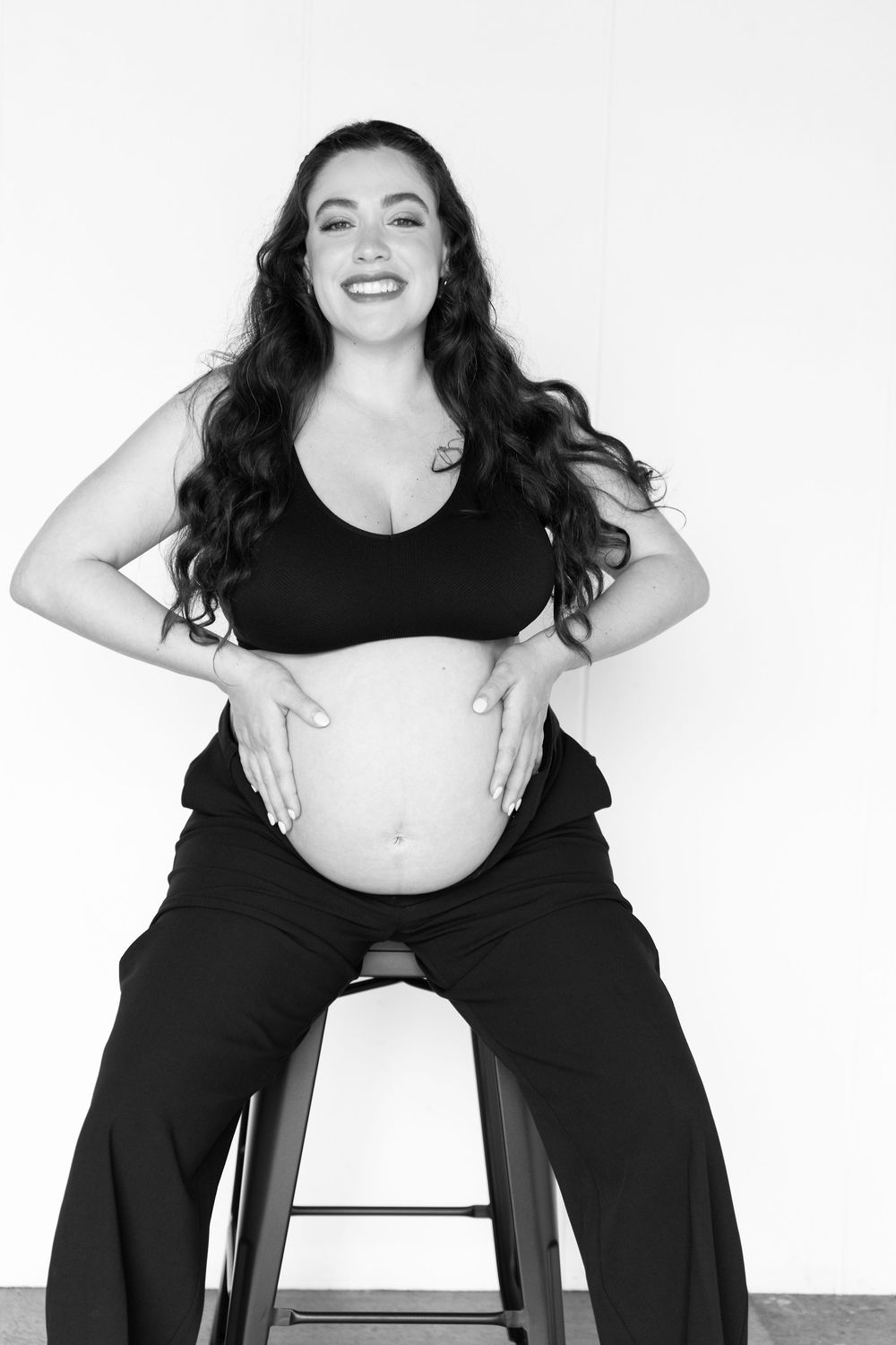 Black and white photo series showing a person in dark clothing sitting and posing playfully against a white background.