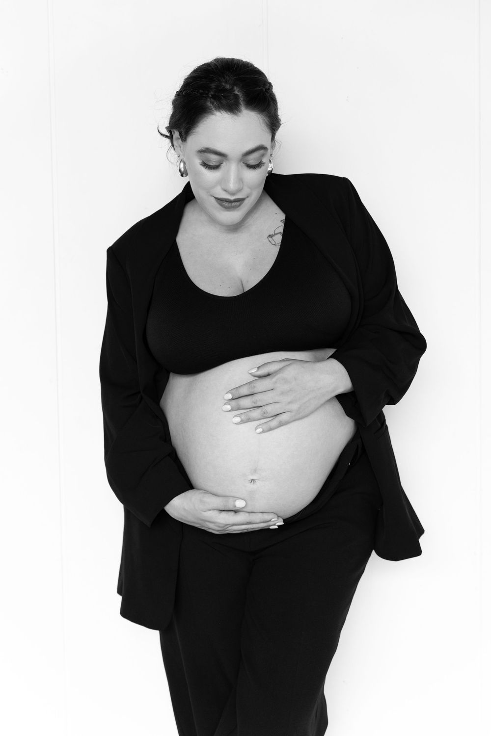 Black and white artistic photo series showing a person in dark clothing holding their stomach in three different poses.