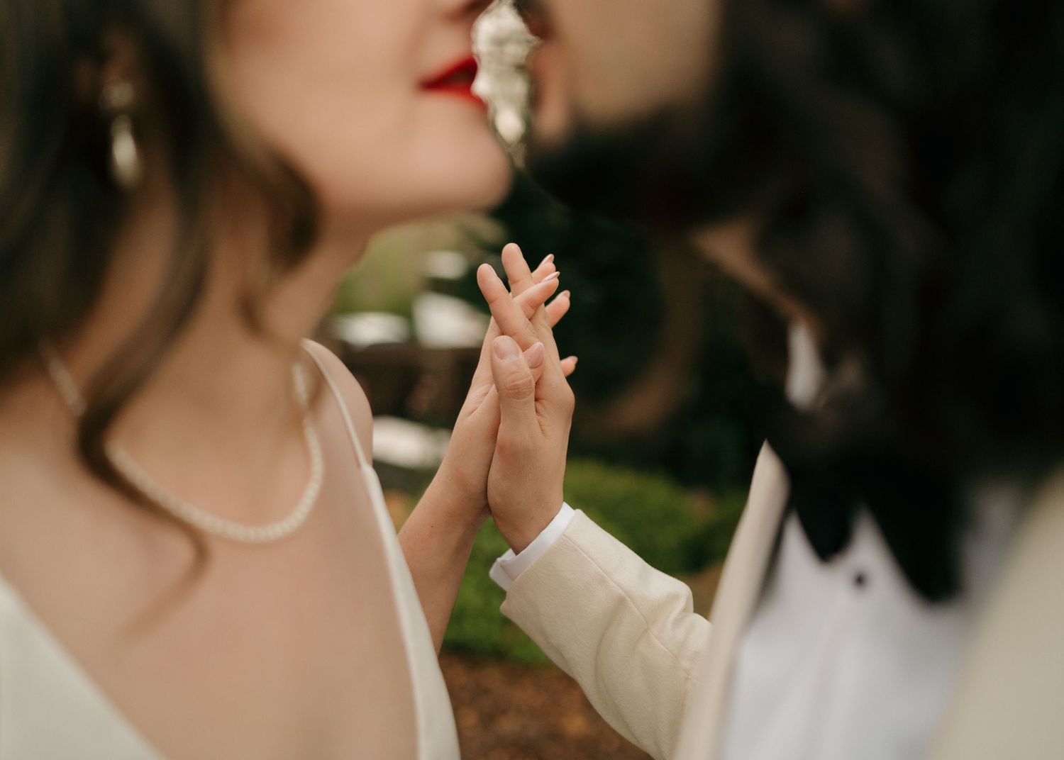 Intimate close-up of hands touching during a romantic moment outdoors.