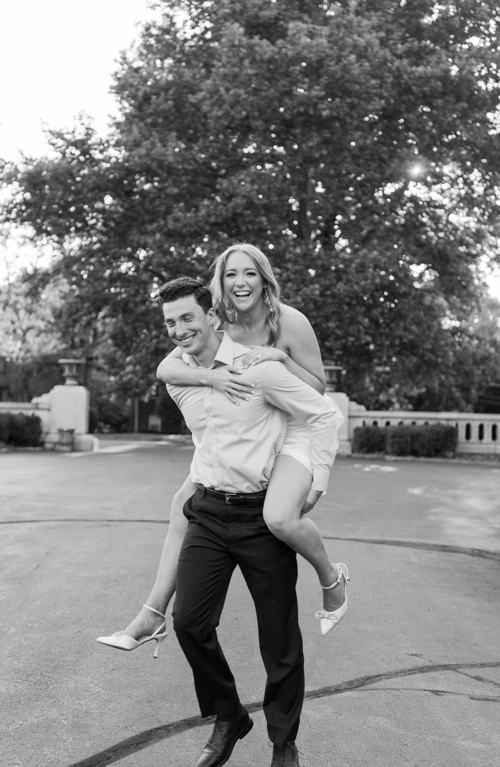 A playful black and white sequence of four frames showing a couple engaging in a lighthearted outdoor moment.