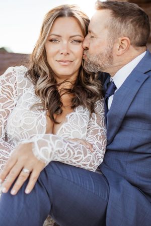 wedding photo, newlywed, bride looking into camera, husband kissing her cheek, love, wedding photographer, Moncton, Riverview, Dieppe.