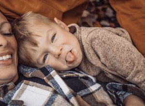 little boy, sticking out his tongue at camera, funny moment, candid photography, outdoor photography, fall.