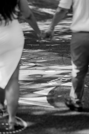 Feet of people dancing on a black and white checkered dance floor in a blurred motion effect.