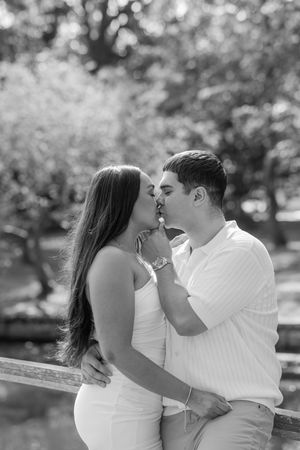 A romantic black and white photo sequence shows a couple embracing and kissing in an outdoor park setting.