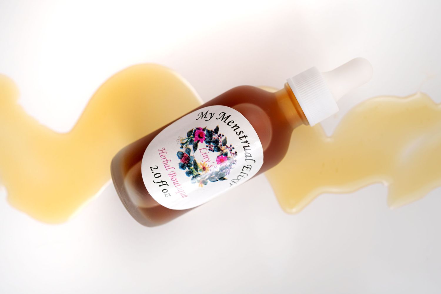 Amber glass bottle of herbal tincture photographed against wavy yellow background.