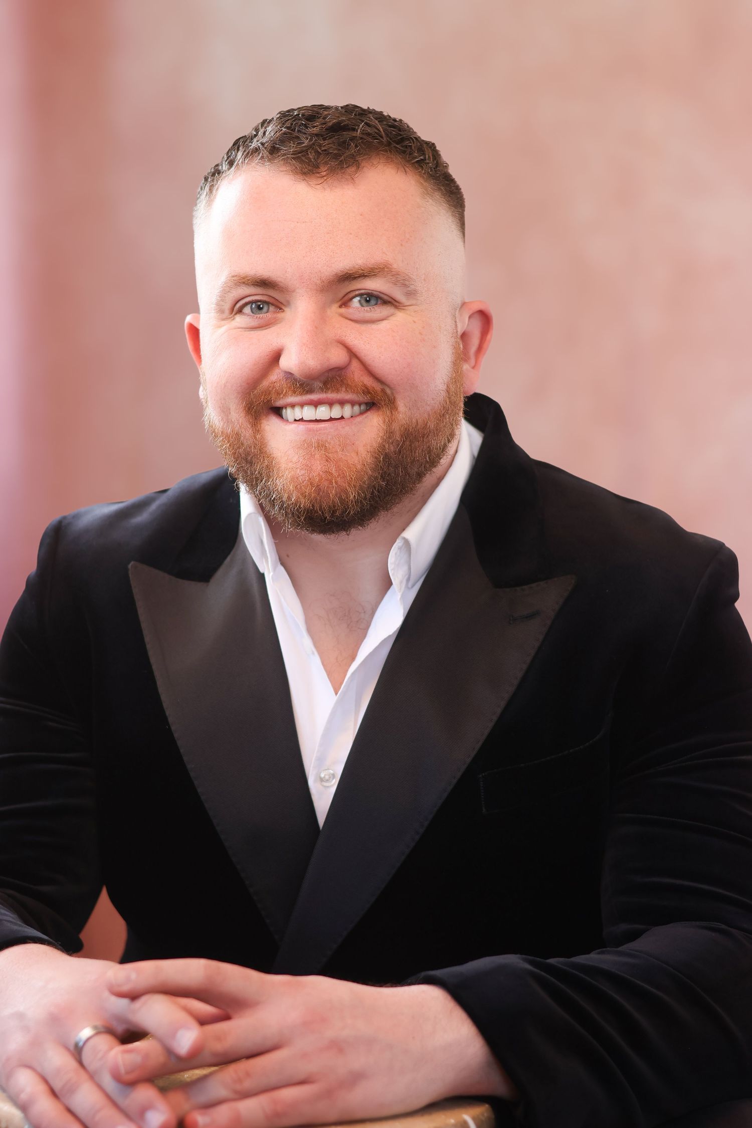 Professional portrait of person in black velvet tuxedo jacket.