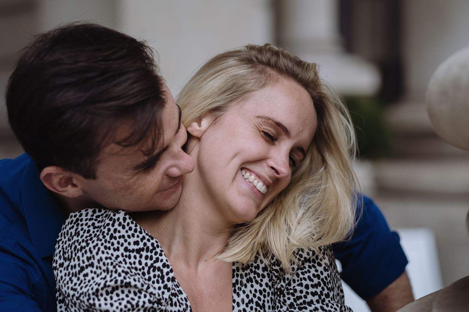 Man smiling over a woman's shoulder and smiling together
