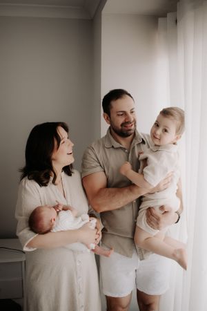 Family photo of mum, dad, toddler and newborn.