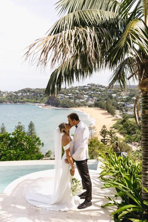 A romantic beach wedding photoshoot with palm trees and ocean views in a tropical paradise.