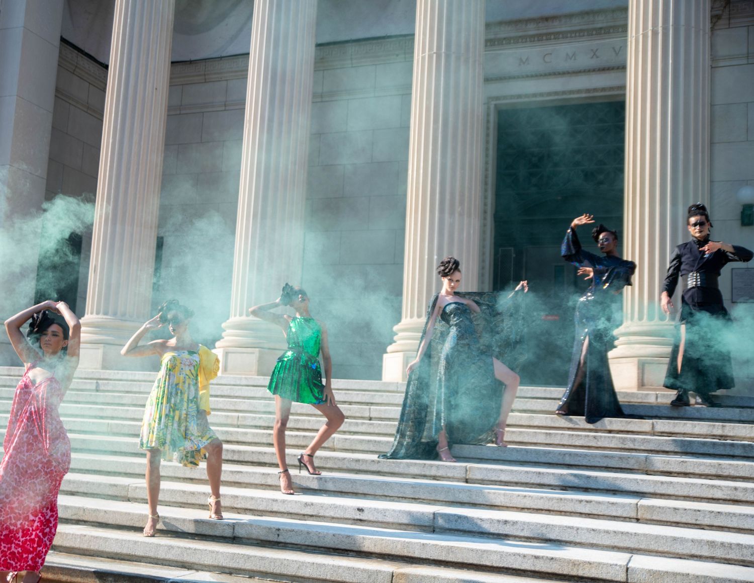 Colorful smoke bombs create dramatic effect on classical building steps during photo shoot.