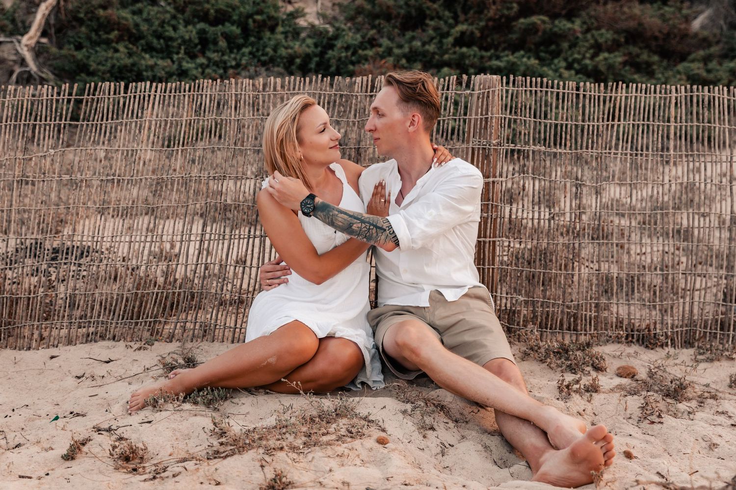 Couple looking into eachothers eyes during a romantic beach engagement session.