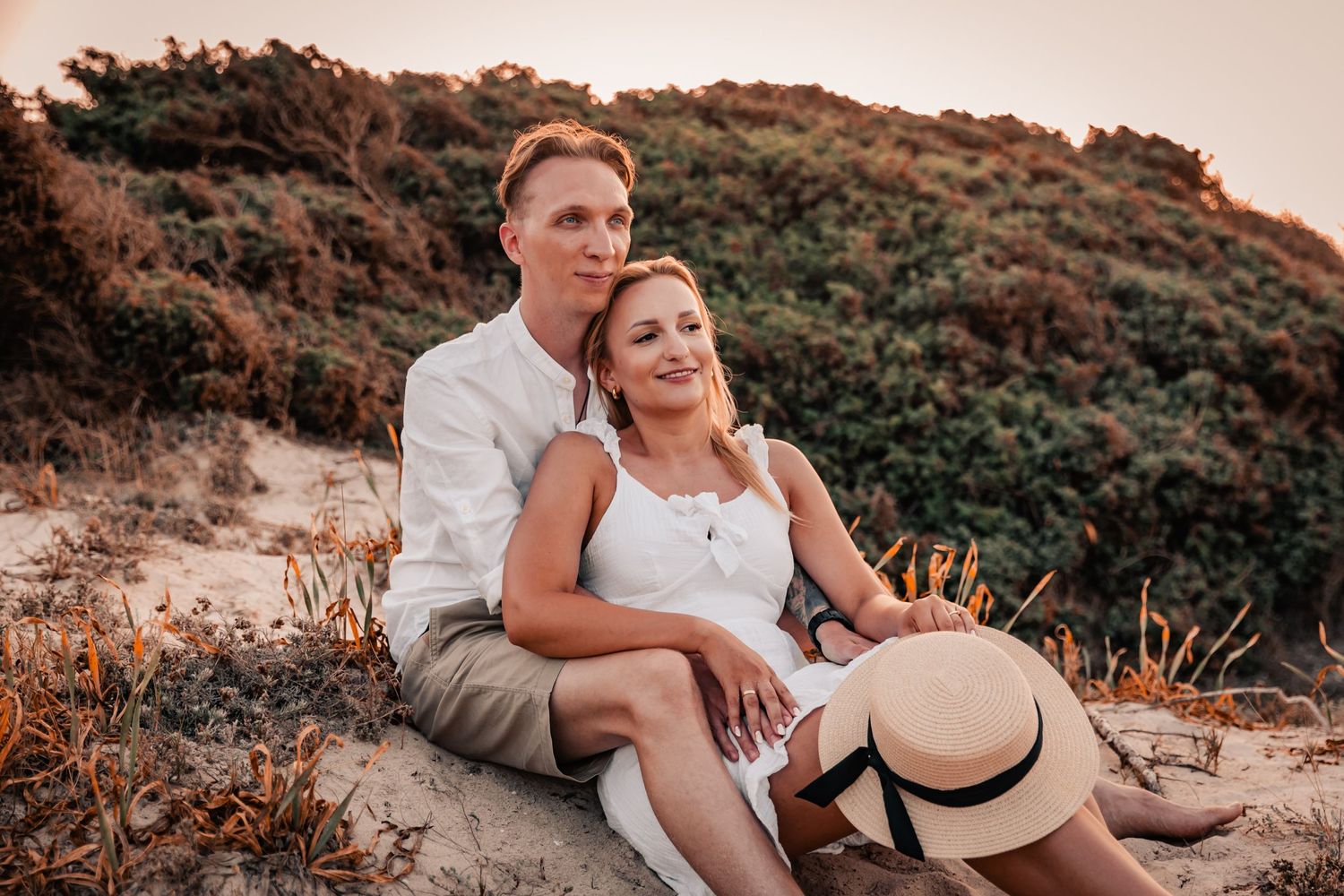 Close-up of a couple's emotional embrace on the beach at sunset.