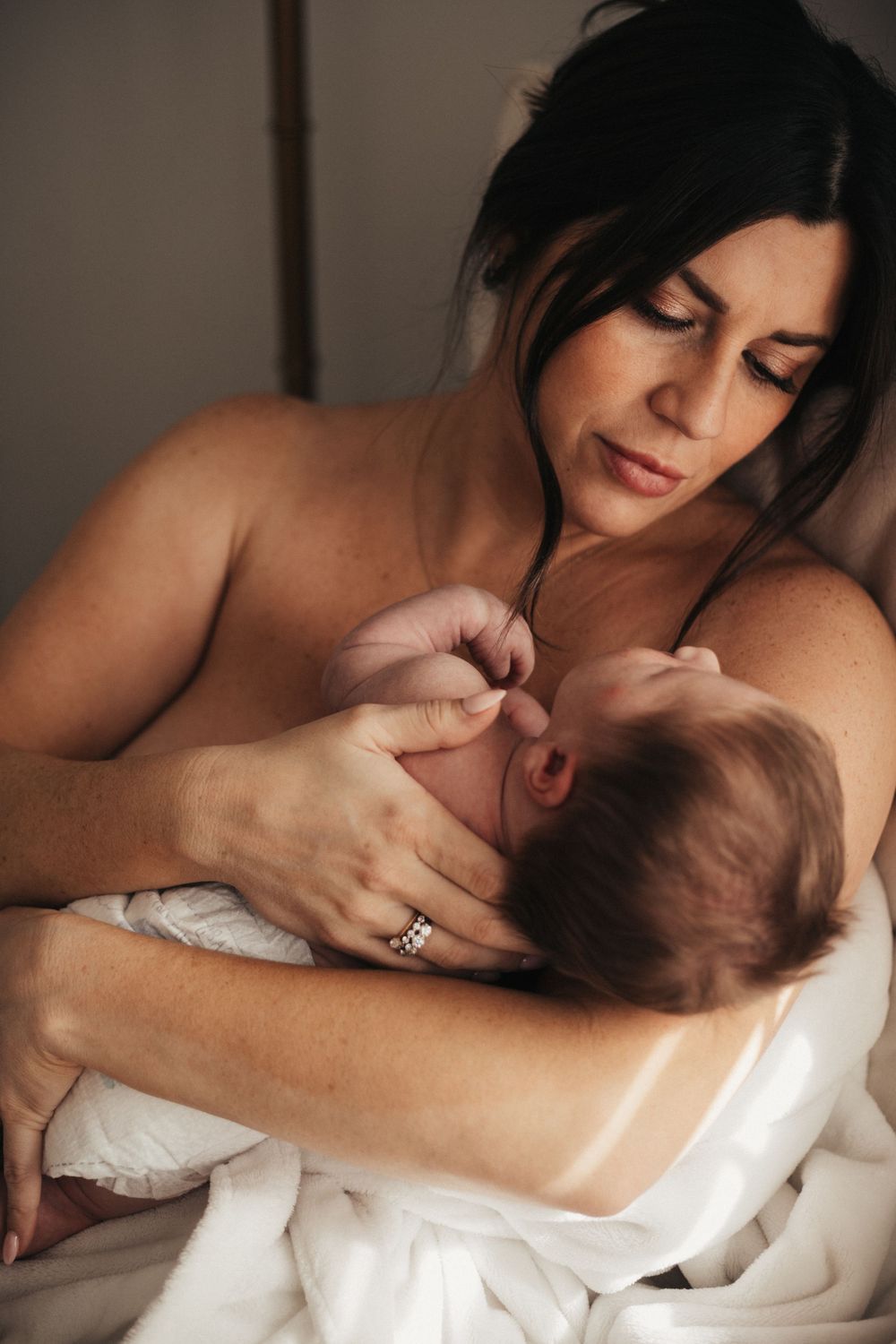 An intimate nursing moment captured in soft, natural light.