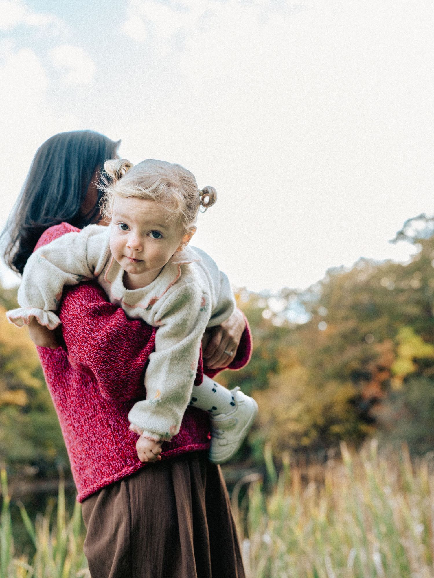 A loving family moment outdoors on a sunny spring day in Belmont, MA.