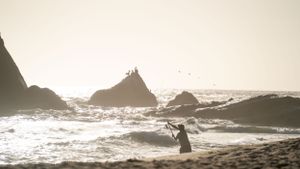 Panoramic view of rugged coastline with waves crashing against rocky outcrops.