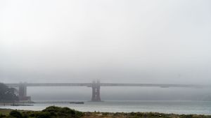Foggy view of Golden Gate Bridge spanning San Francisco Bay.