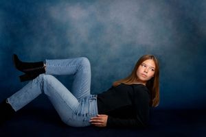 Moody and artistic photoshoot sequence of person in denim jeans against dark background creating dramatic poses.