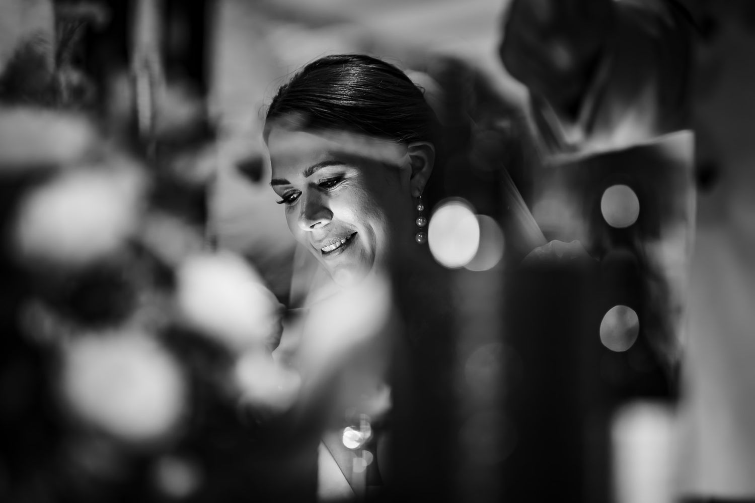 Black and white image shows a side profile view focusing on facial features in a dark, atmospheric setting.