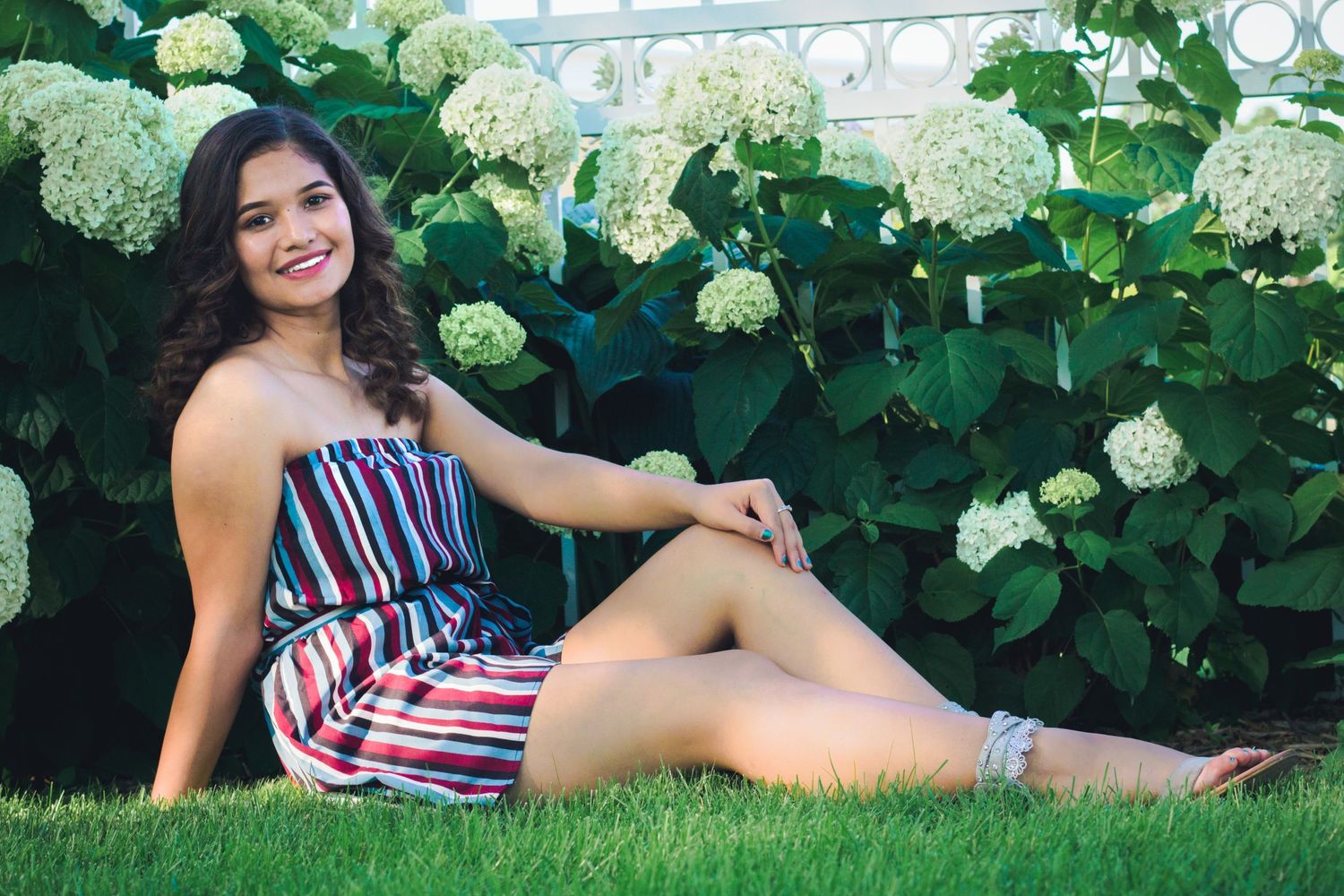 Lifestyle portraits among flowering hydrangea bushes in a garden setting.