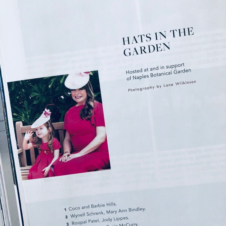 Magazine page titled Hats in the Garden featuring a woman and child in red dresses at Naples Botanical Garden.