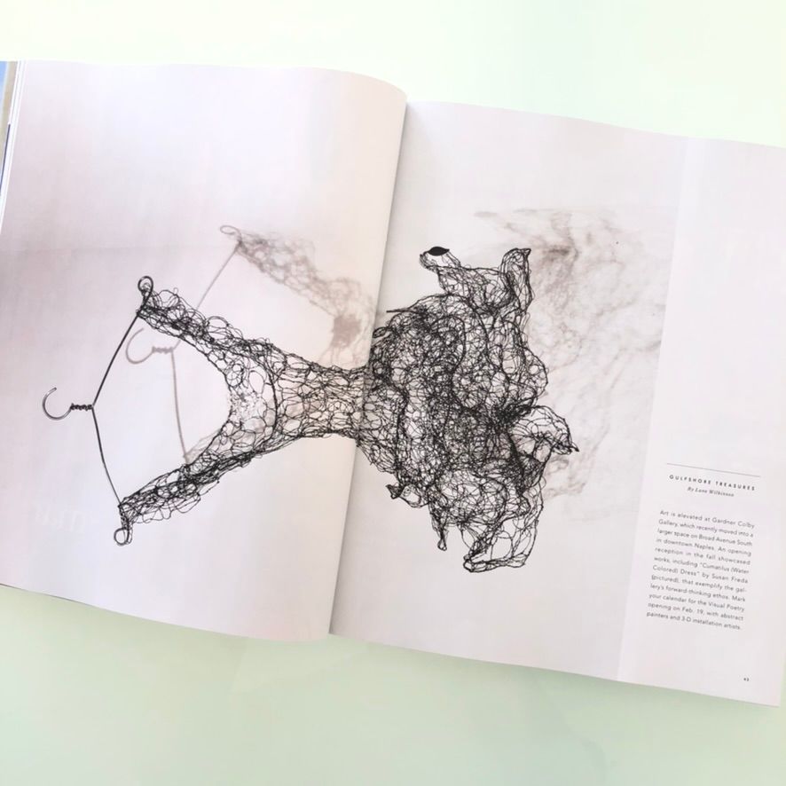 Open magazine spread showcasing a detailed wire art sculpture of a dress with flowing abstract forms.