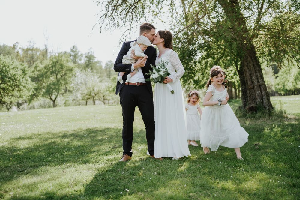 An intimate wedding moment captured under a blooming tree during springtime.