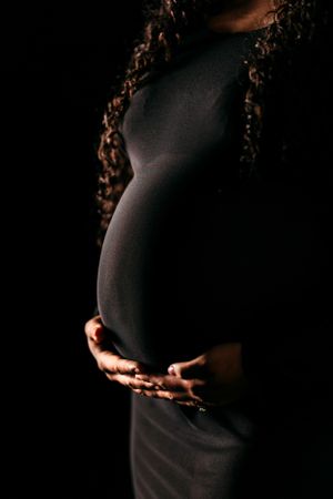 Artistic silhouette maternity photos showing pregnant belly against dark background. Middle TN Maternity Photographer