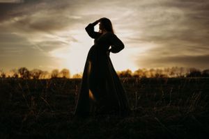 Dramatic silhouette photography at sunset in a grassy field.Middle TN Maternity Photographer