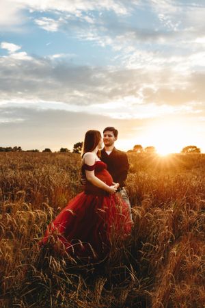 Romantic couple photoshoot in wheat field during golden hour sunset. Middle TN Maternity Photographer