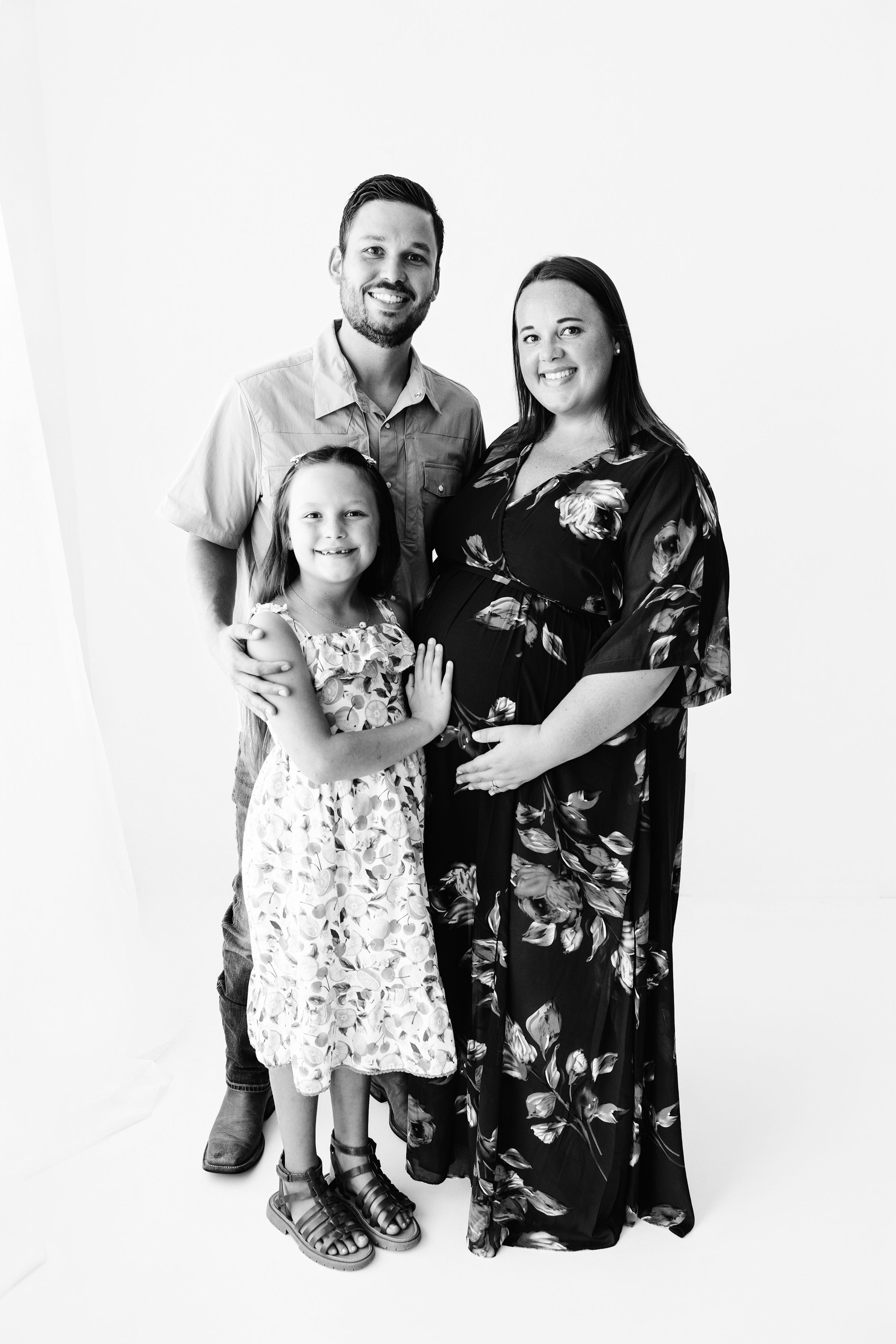 Black and white family portrait series showing three poses of parents and young child in coordinated outfits.