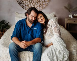 Intimate couple's maternity portrait session featuring denim and white lace on a tufted couch. Middle TN Maternity Photographer
