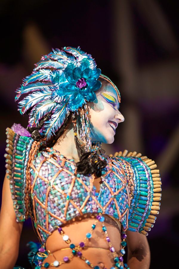 Elaborate turquoise feathered headdress and beaded costume detail from recycled fashion show.