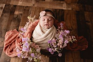 baby girl in prop with purple flowers