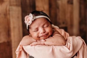 Little girl with cute smirk during newborn session