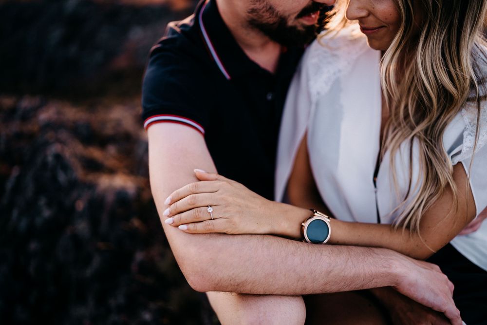 Intimate close-up showing gentle embrace and smart watch detail.