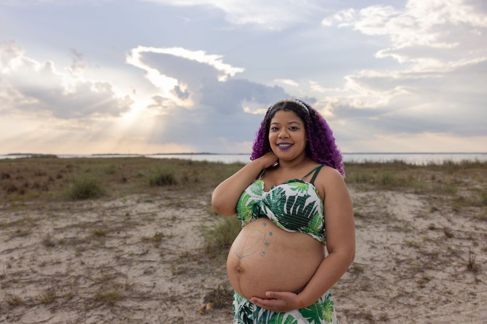 A sunny outdoor maternity portrait with tropical palm print outfit.