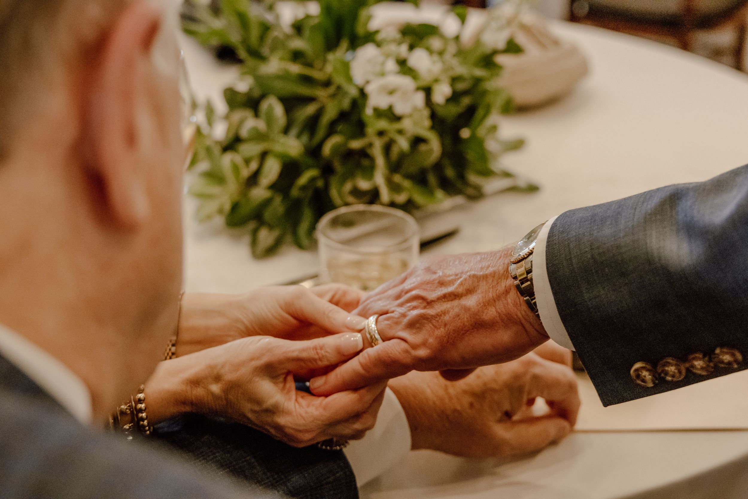 A man showing is wedding band to family, who holds his hand and admires the new ring. Tallahassee, FL.
